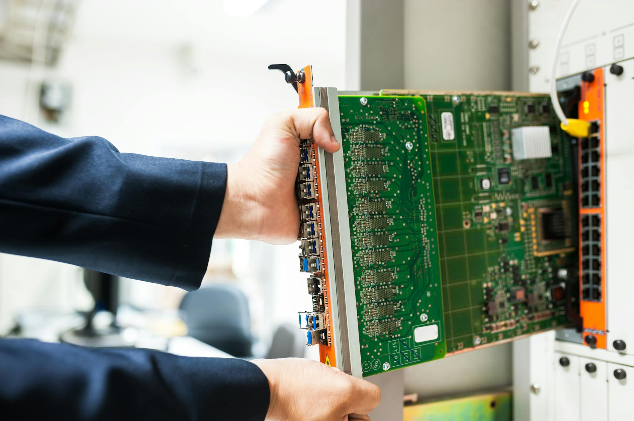 A Technician Inserts A Circuit Board Into